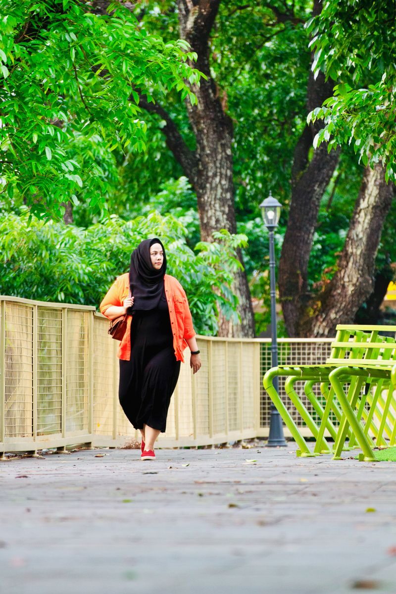 Illustrative photo: woman walking in a park on a sunny day